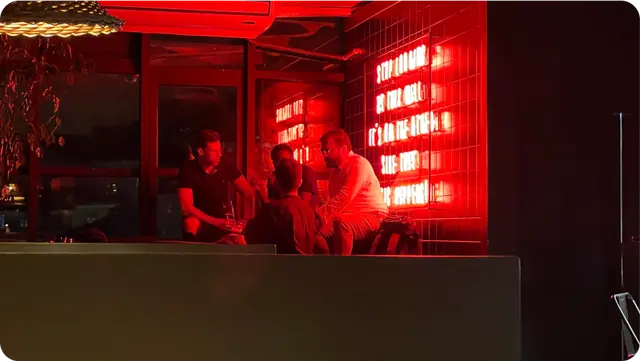 The team at a table in a bar lit red