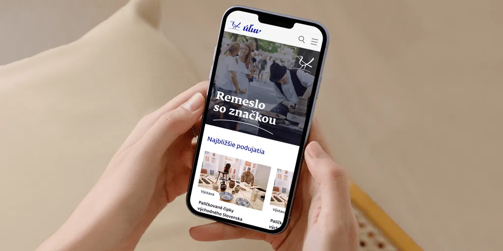 The ÚĽUV home page on a phone held in two hands