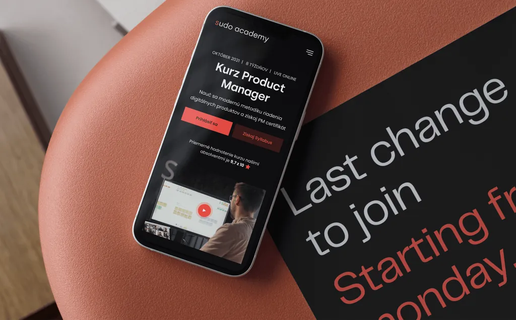 The Sudo Academy “Kurz Product Manager” (Product Manager course) page on a phone, lying beside a black printed flyer